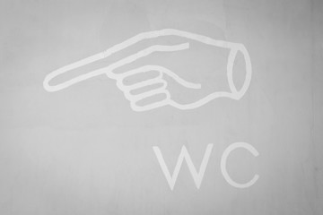 WC (water closet) or  toilet sign on gray concrete wall