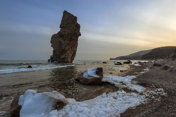 High, a lone rock on the coast.