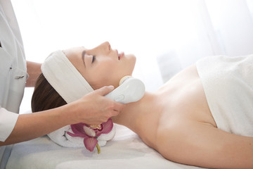 Fototapeta na wymiar Spa salon: Young Beautiful Woman Having Facial Massage .