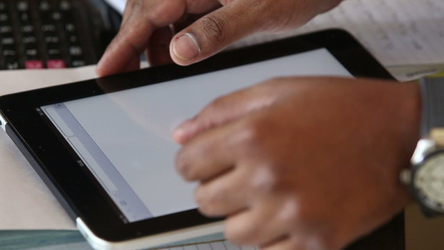 man is holding a tablet on the table and waiting 