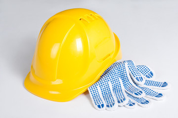 yellow builder's helmet and work gloves over white