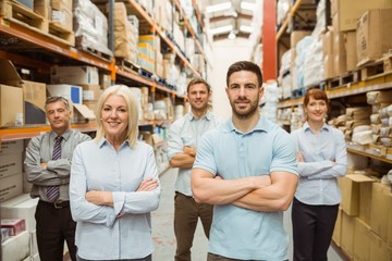 Smiling warehouse team with arms crossed