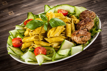 Pasta with pesto sauce, fried chops, parmesan and vegetables