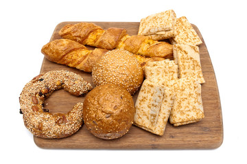 baked goods and pancakes on a cutting board isolated on white ba