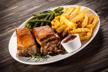 Barbecued ribs, French fries and vegetables