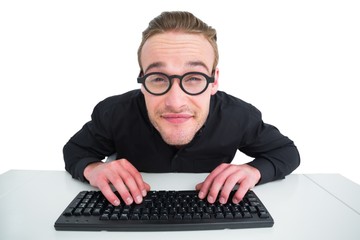 Smiling businessman typing on keyboard at desk