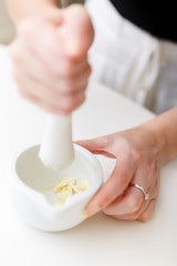 Female hands with a mortar and garlic