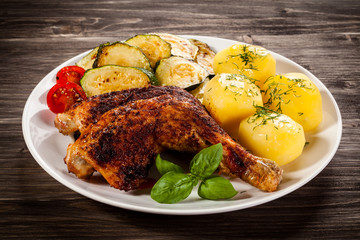 Barbecued chicken leg with boiled potatoes and vegetables