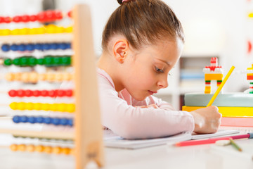 Little girl is doing homework.