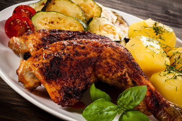 Barbecued chicken leg with boiled potatoes and vegetables
