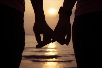 love couple holding hands fingers at sunset on the beach, valent - 76807417