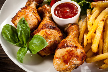 Grilled chicken legs with chips and vegetables