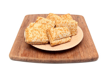 Russian pancakes on a plate on a cutting board isolated on white