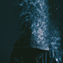 Faceless unrecognizable man vanishing into dust