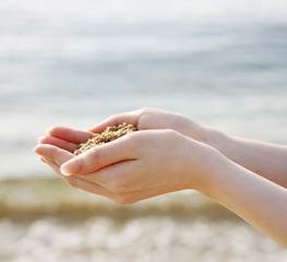 海の砂と女性の手