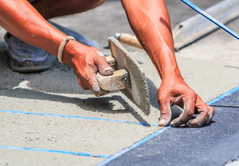 Plasterer concrete worker smooth the cement  with trowel