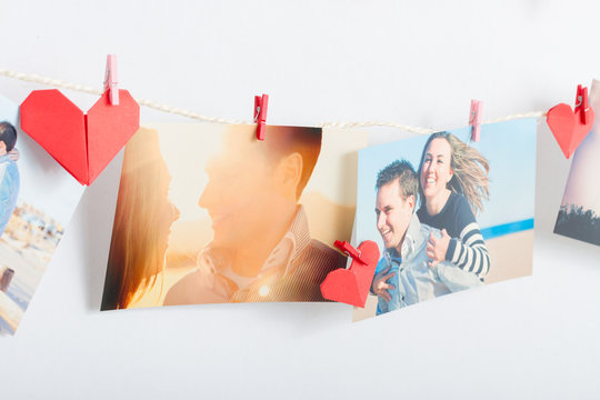 Photos hanging on clothesline with origami hearts
