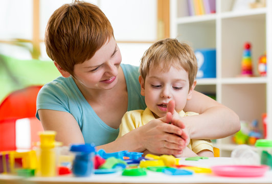 child boy and mother playing colorful clay toy