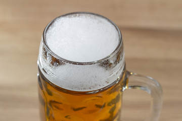 Beer with a frothy head in a glass beer mug
