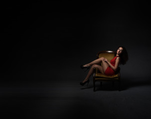 model in red dress sitting in a strange mode