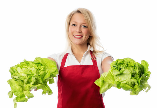 Frau in Kochschürze hält Salatköpfe