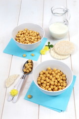 Corn flakes in bowl and  milk on a white background