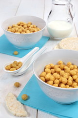 Ñorn flakes in bowl and  milk on a white background