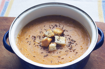 Carrot cream soup with croutons and caraway seeds