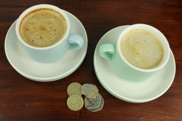 English Currency with two coffee cups.