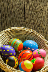Easter eggs in basket and wood background