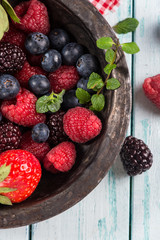Fresh summer berries fruits in vintage bowl on rustic table