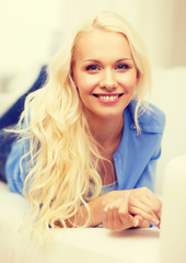 smiling young woman lying on sofa at home