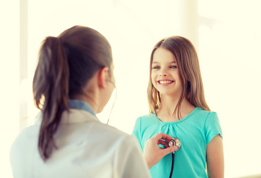 female doctor with stethoscope listening to child