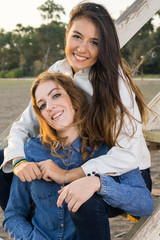 Naklejka premium Female Best Friends Sitting on Wooden Stairs.