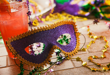Mardi Gras: Party Mask Sits Against Tropical Hurricane Cocktail - obrazy, fototapety, plakaty