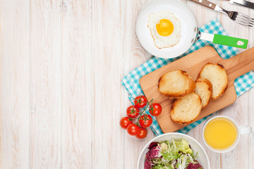 Healthy breakfast with fried egg, toasts and salad
