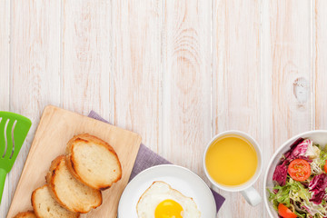 Healthy breakfast with fried egg, toasts and salad
