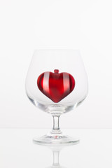 Red heart inside a glass of cognac