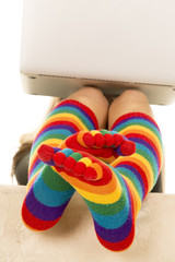 feet in colored socks under laptop crossed