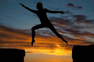 silhouette of a woman jumping arms out