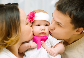 Parents kiss baby