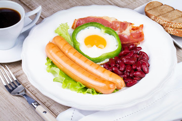 Egg fried in a green pepper, sausages, bacon and red beans