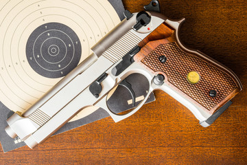 Target shooting, the gun and the target on the table. Top view