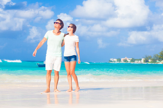 happy young couple in sunglasses on the beach