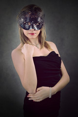 Beautiful girl in a black carnival mask