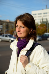 Concentrated woman on a city street, waiting for transport