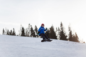 Young boy riding snowboard