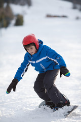 Young boy riding snowboard