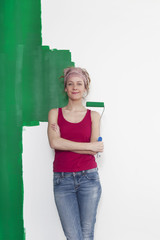 Frau mit Farbrolle vor Wand
