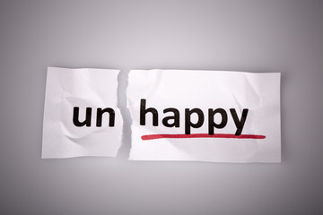 The word unhappy changed to happy on torn paper